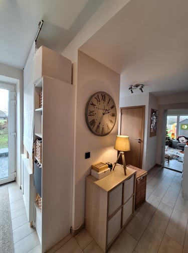 Image d'une entrée avec des meubles de rangements et une horloge