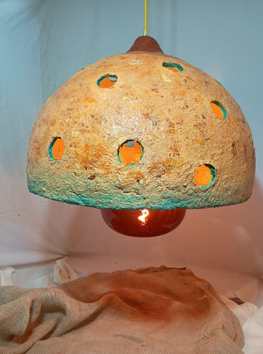 Rustic handmade dome pendant light with a textured earth-tone finish and circular cutouts.