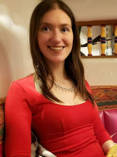 Stephanie Marie, Super Wellness Woman, wearing a red dress and a necklace, smiling a the camera.