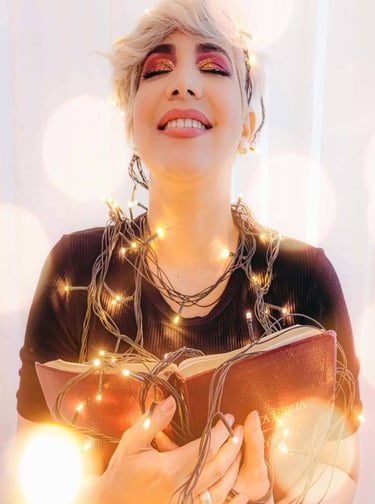 Woman holding a Bible wrapped in lights, symbolizing God’s Word bringing hope and light.