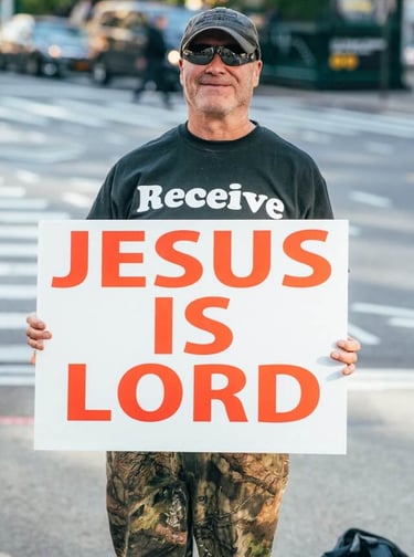 a man holding a sign that says jesus is lord