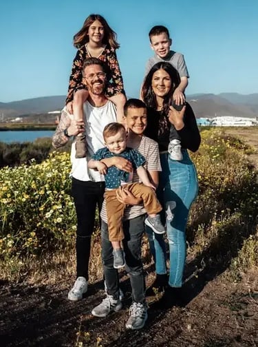 large young caucasian family smiling at sunset by a river in the country