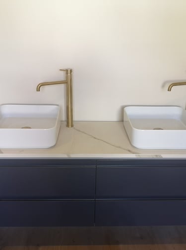 meuble bleu de salle de bain, vasques à poser carrées, robinetterie bronze grand bec.