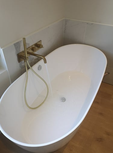 Baignoire ilot, robinetterie bronze encastrée, faïence marbre blanc.