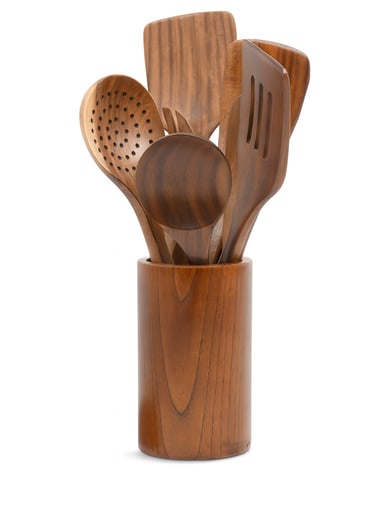 Teak wood kitchen utensils arranged in a matching round holder, including spatulas and spoons