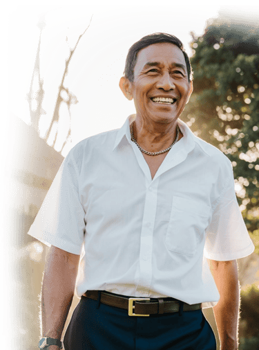 A smiling senior Asian man walking outdoors in the sunlight a stem cell therapy patient 