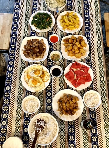 a table with plates of food and a bowl of rice