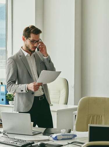 Young businessman talking consulting with a client on the phone and looking at documents.and