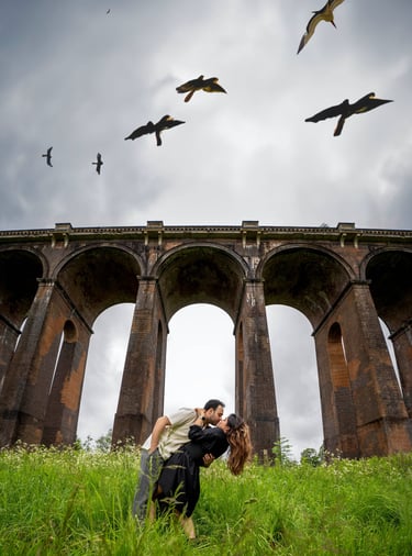 Romantic couple under bridge with birds in sky – cinematic outdoor photography by Fred Art Studio