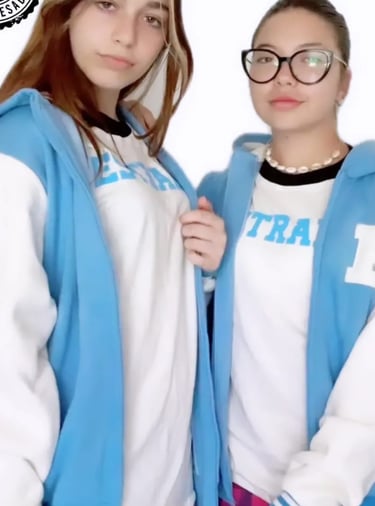 two women in blue jackets and glasses posing for a photo