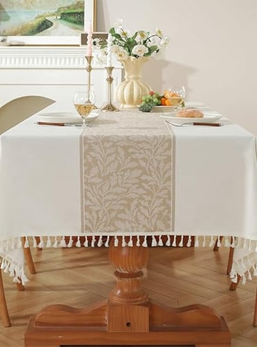 Neutral cotton-linen tablecloth with decorative tassel border, styled for a cosy rustic dining look.