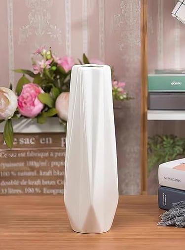Tall white ribbed ceramic vase filled with blush pink flowers, elegant home styling piece.