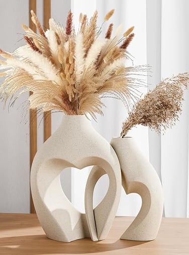 White heart-shaped ceramic vase with soft dried floral arrangement, romantic home décor accent.