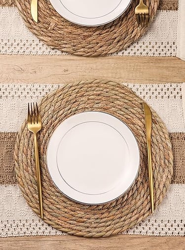Set of round woven boho placemats in natural straw tones, rustic table styling décor.