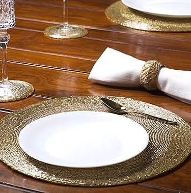 Set of beaded hand-crafted charger mats in warm neutral tones, luxury table setting accents.