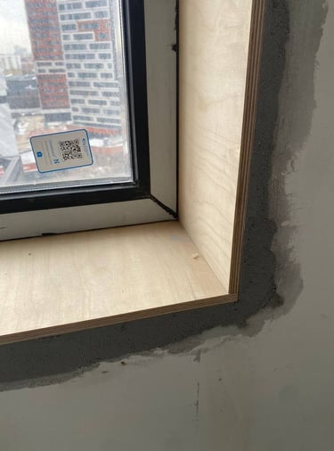 Habillage intérieur de baie vitrée avec encadrement en bois brut sur chantier