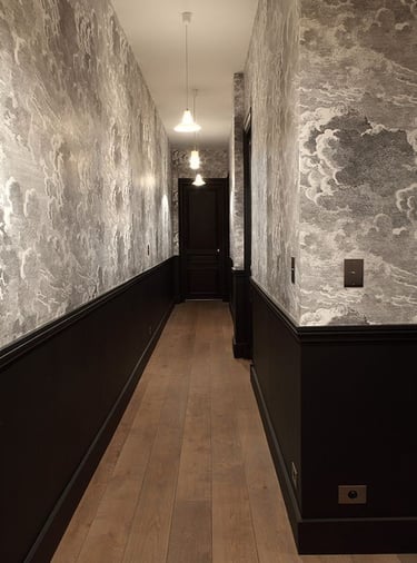 Rénovation intérieure avec pose de parquet et papier peint texturé dans un couloir haut de gamme