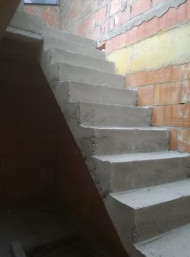 Escalier en béton brut réalisé sur mesure dans une cage d’escalier maçonnée