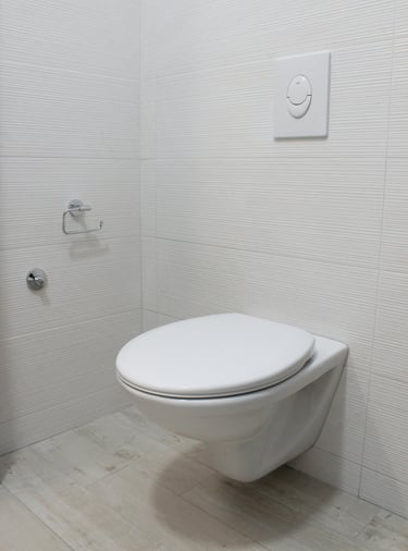 Toilettes suspendues installées dans une salle de bain carrelée au sol et aux murs