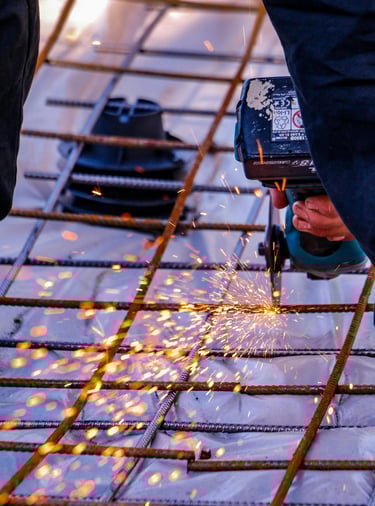 Découpe de ferraillage au disque pour armature béton sur chantier de gros œuvre