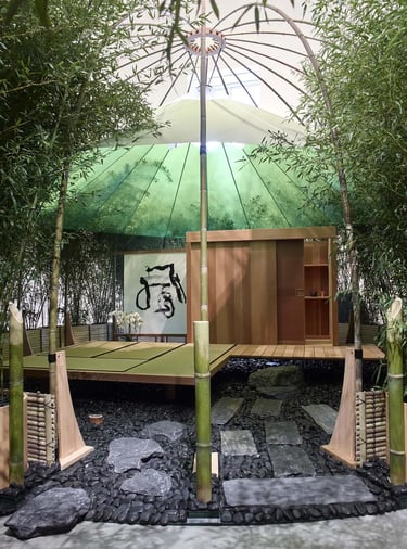 Bamboo garden pavilion with low wooden platform and parasol, reflecting Charlotte Perriand’s connect
