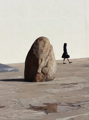 Natural rock sculpture in Noguchi Garden, surrounded by stone paving and quiet open space