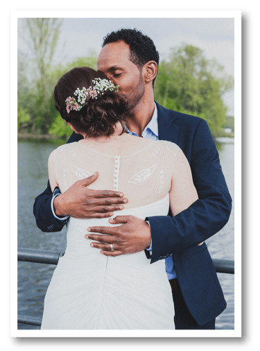 Mixed newlywed couple hugging.