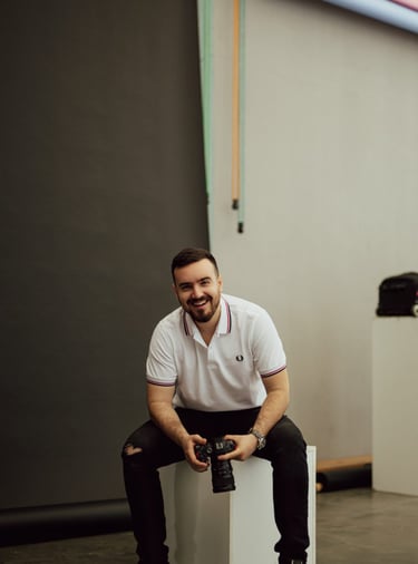 a man sitting on a white cube with a camera