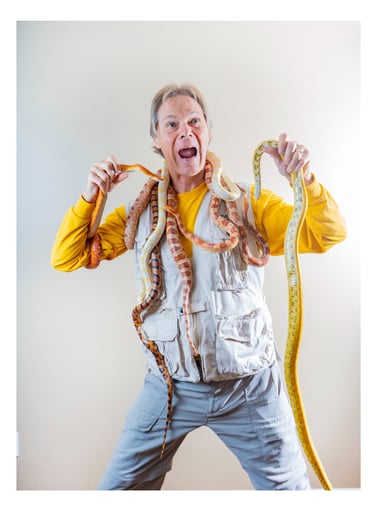 Rick holding an assortment of snakes in a yellow shirt and vest
