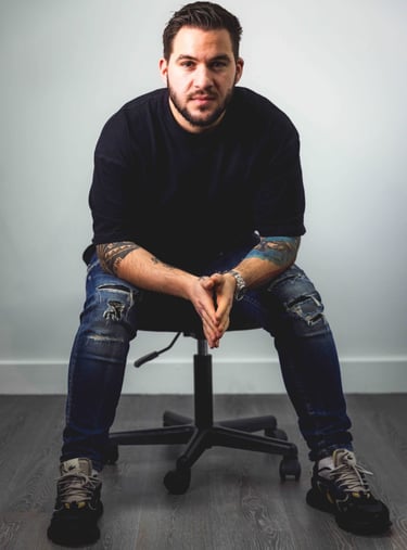a man sitting on a chair with his hands on his knees
