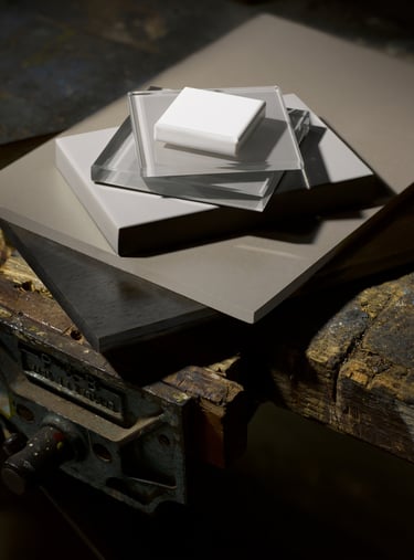 pieces of tile slate and glass stacked on top of an old wooden workbench and vice
