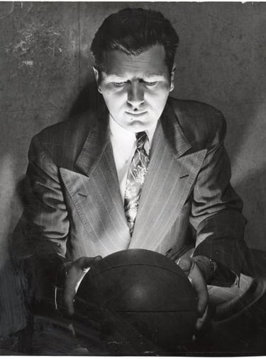 Photograph of Basketball Player Hank Luisetti starting at basket ball Stewart Chevrolets 1950