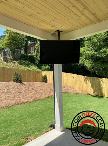 Outdoor TV installed on a ceiling mount bracket on the patio