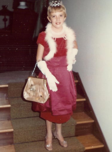 a young girl in a red dress and white fur stole