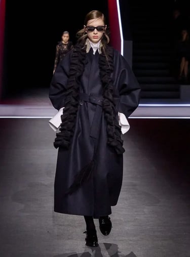 Navy coat with ruffled scarf at Dior FW25 show.