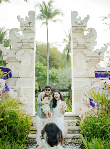 Family standing at a traditional Balinese gate during a family photography session in Nusa Dua Bali.