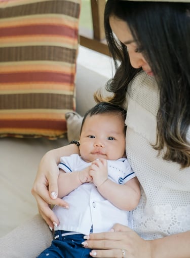 Mother holding her baby during a family photography session at Samabe Bali Suites & Villas in Nusa Dua.