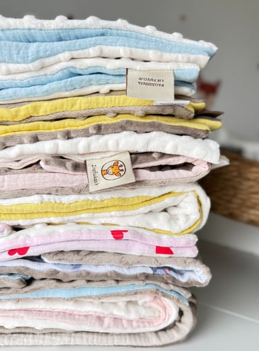 įvairių spalvų vaikiškų pledukų rinkinys