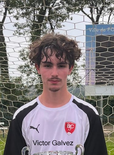 un homme tenant un trophée devant un gardien de but de football