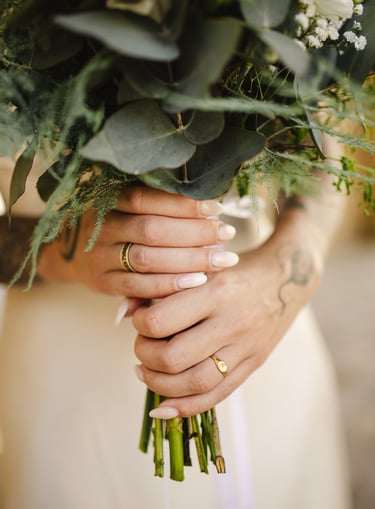 Une mariée qui tient un bouquet de fleur et son alliance
