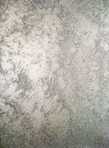 A cool silver paint sample showing off its shimmering grainy texture.
