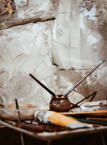 image of an artist's workbench with paint and paintbrushes