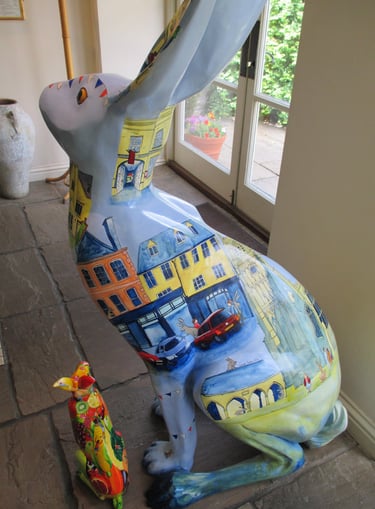 Hare sculpture featuring Cirencester scenes, painted by Laura Fearn