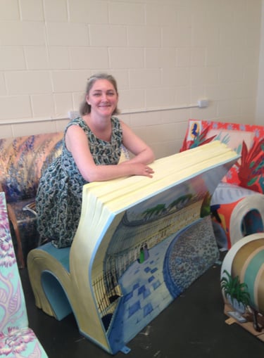 Laura Fearn kneeling on her Sitting With Jane bookbench