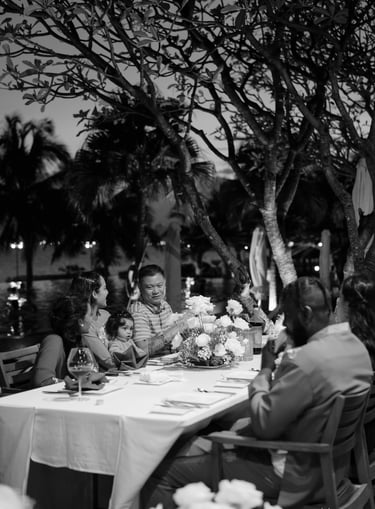 a family sitting at a table with a man in a suit