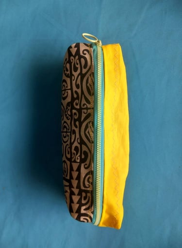 Handmade fabric zipper pouch featuring a brown tribal print pattern and bright yellow lining.