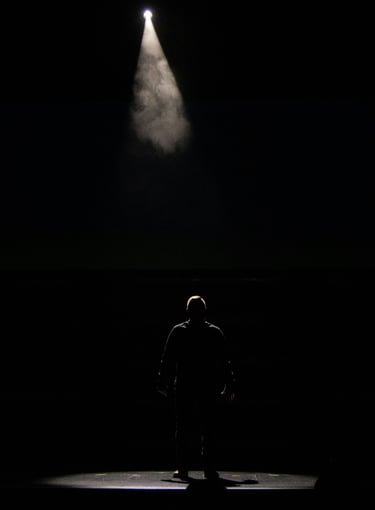 a man standing in front of a spotlight light