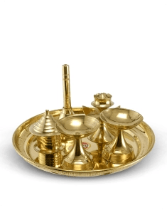 small brass items for pooja placed in a plate