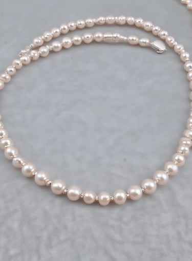 Elegant jewelry pieces featuring intricate designs with pearls and gold accents are displayed against a soft, textured background. The jewelry includes earrings that combine black stones and clusters of pearls with shiny embellishments.