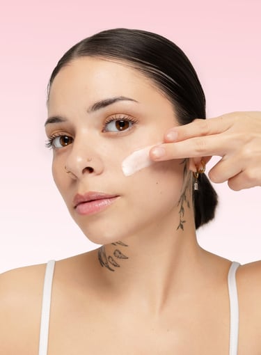 a model applies a skincare product in her face